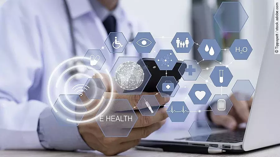 Ein Arzt hält ein Tablet in den Händen. Über dem Gerät schweben Symbole und Icons in einer hologrammartigen Darstellung.