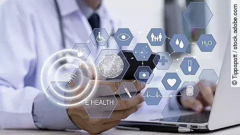 Ein Arzt hält ein Tablet in den Händen. Über dem Gerät schweben Symbole und Icons in einer hologrammartigen Darstellung.