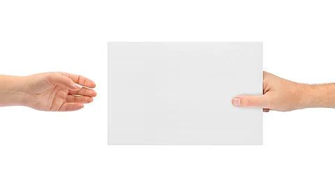 Ein Blatt Papier wird von der rechten Hand in die linke übergeben