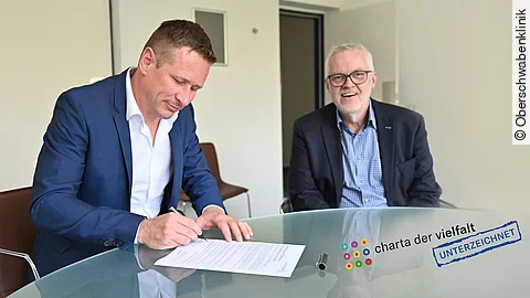 OSK-Geschäftsführer Prof. Dr. Oliver Adolph (links) und Michael Schuler unterzeichnen die „Charta der Vielfalt“.