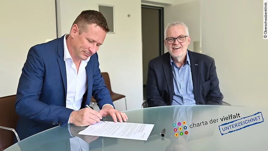 OSK-Geschäftsführer Prof. Dr. Oliver Adolph (links) und Michael Schuler unterzeichnen die „Charta der Vielfalt“.