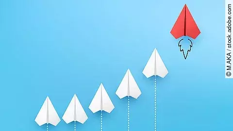 Business Konzept Sechs Papierflieger, die kurvenähnlich angeordnet sind vor blauem Hintergrund. Der rechte und höchste Papierflieger ist rot.