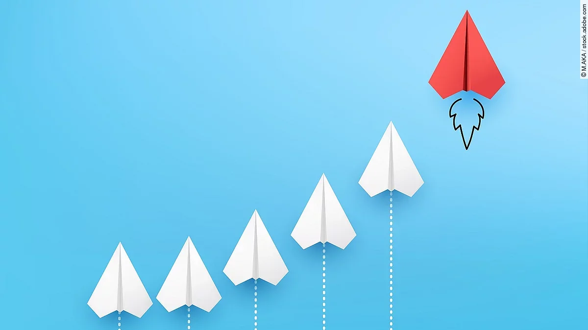 Business Konzept Sechs Papierflieger, die kurvenähnlich angeordnet sind vor blauem Hintergrund. Der rechte und höchste Papierflieger ist rot.