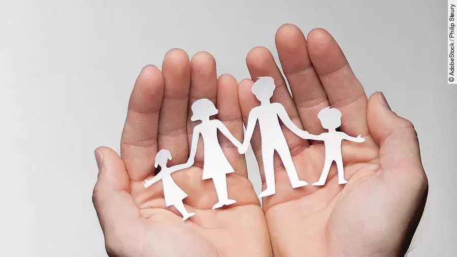 Zwei Hände bilden eine Schale, darin sind die Umrisse einer Familie mit Mutter, Vater und zwei Kindern zu sehen.