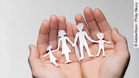 Zwei Hände bilden eine Schale, darin sind die Umrisse einer Familie mit Mutter, Vater und zwei Kindern zu sehen.