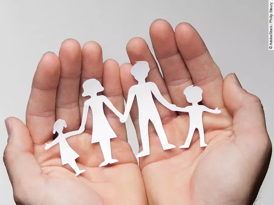 Zwei Hände bilden eine Schale, darin sind die Umrisse einer Familie mit Mutter, Vater und zwei Kindern zu sehen.
