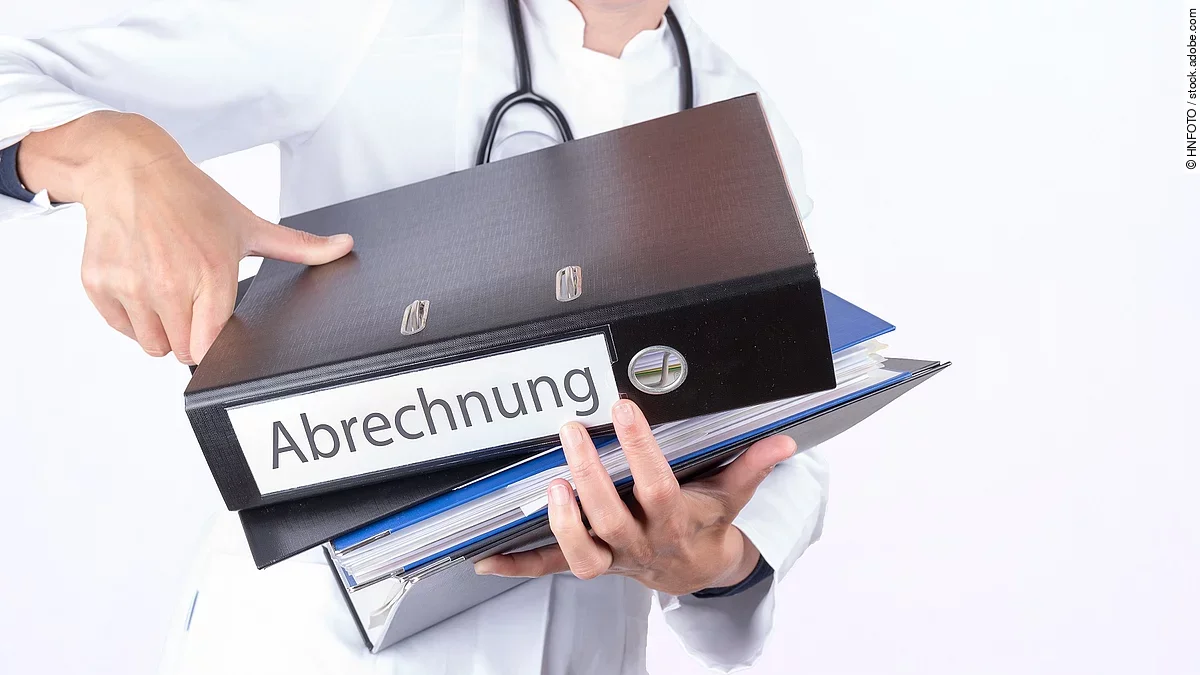 Abrechnung Arzt tägt mehrere Dokumente und Ordner für die Abrechnung.