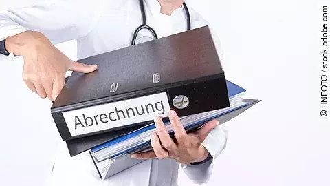 Arzt tägt mehrere Dokumente und Ordner für die Abrechnung.