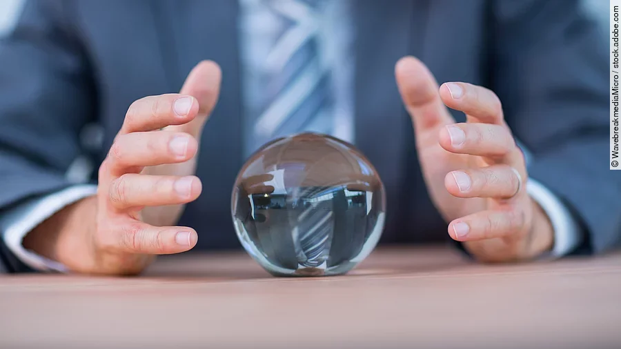 Zukunft Vor einem Anzugträger liegt eine Glaskugel auf dem Tisch.