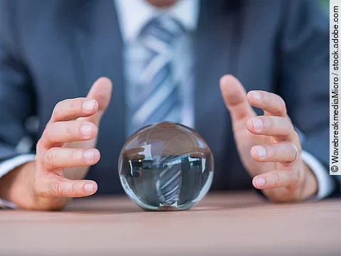Zukunft Vor einem Anzugträger liegt eine Glaskugel auf dem Tisch.