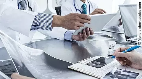 Ärzte im Gespräch Ärzte im Gespräch mit Röntgenaufnahmen und anderen Dokumenten.
