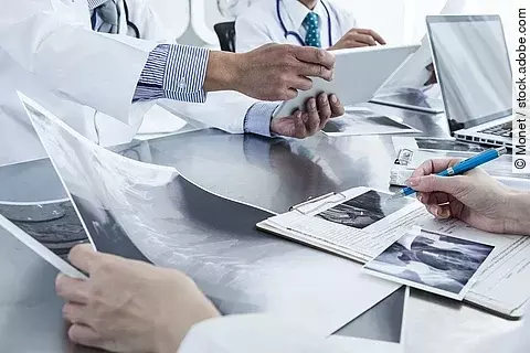 Ärzte im Gespräch Ärzte im Gespräch mit Röntgenaufnahmen und anderen Dokumenten.