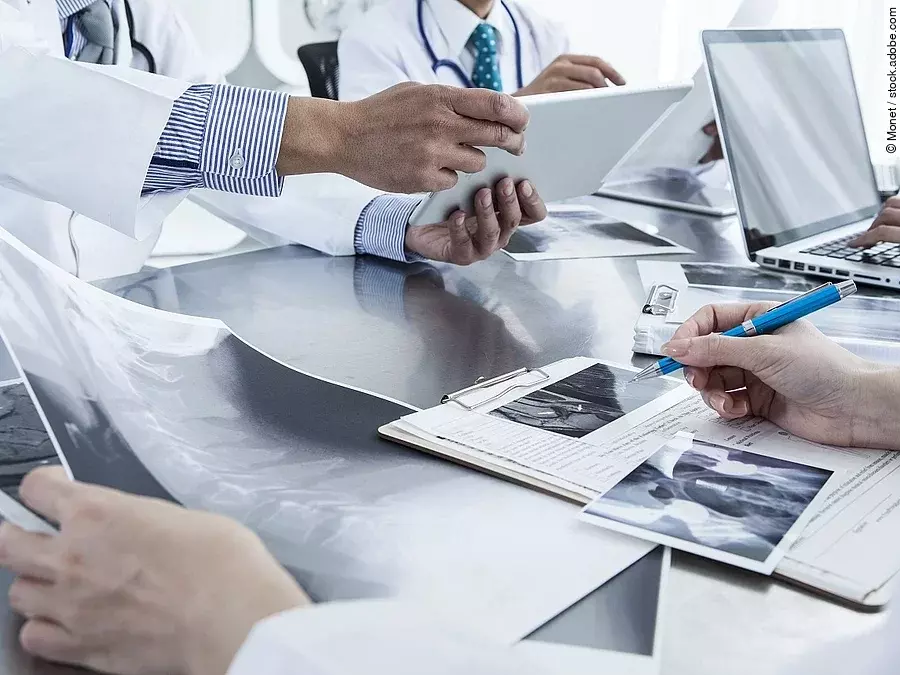 Ärzte im Gespräch Ärzte im Gespräch mit Röntgenaufnahmen und anderen Dokumenten.
