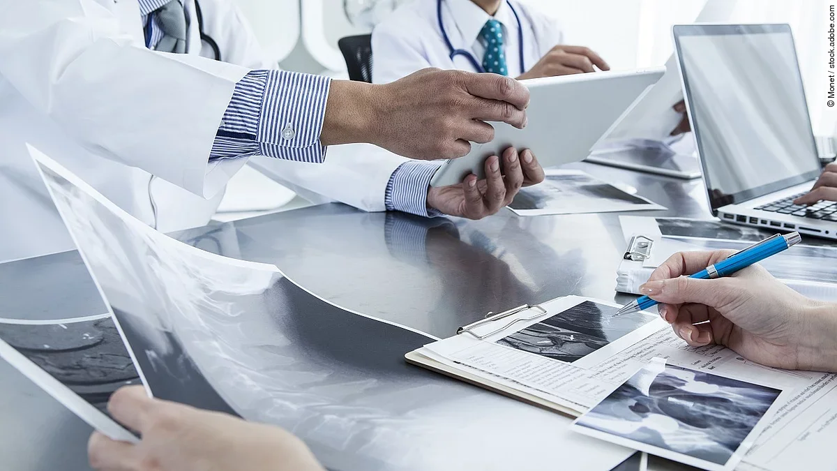 Ärzte im Gespräch Ärzte im Gespräch mit Röntgenaufnahmen und anderen Dokumenten.