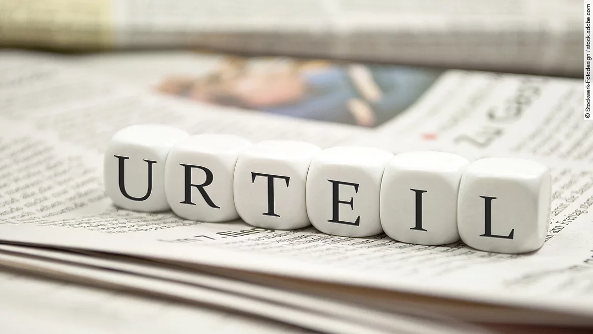 Urteil Buchstabenwürfel bilden das Wort "Urteil". Sie liegen auf einer Zeitung.