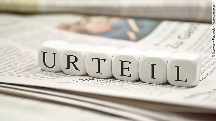 Buchstabenwürfel bilden das Wort "Urteil". Sie liegen auf einer Zeitung.