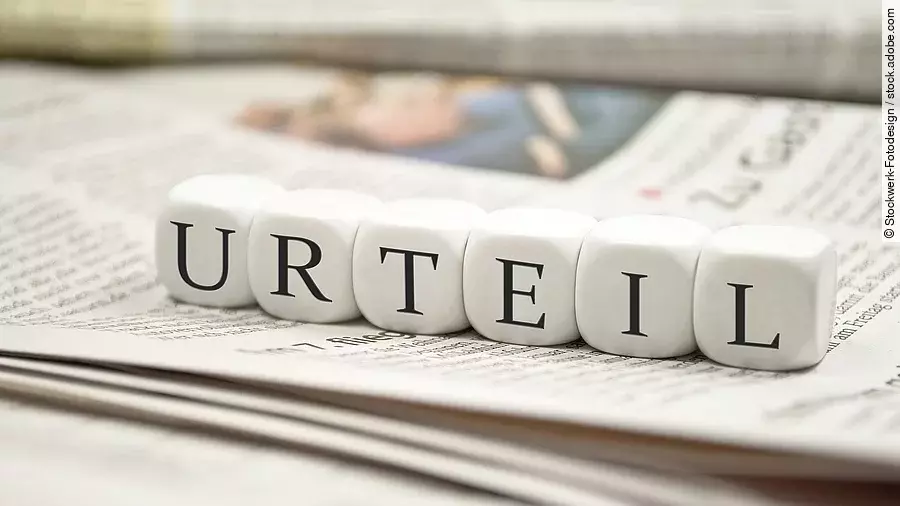 Buchstabenwürfel bilden das Wort "Urteil". Sie liegen auf einer Zeitung.