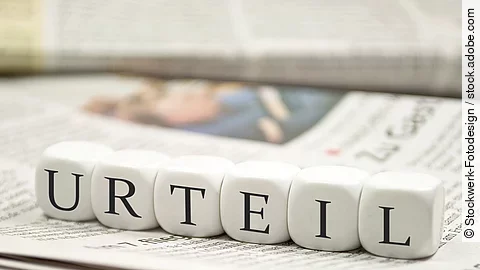 Urteil Buchstabenwürfel bilden das Wort "Urteil". Sie liegen auf einer Zeitung.