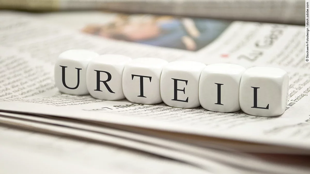 Buchstabenwürfel bilden das Wort "Urteil". Sie liegen auf einer Zeitung.