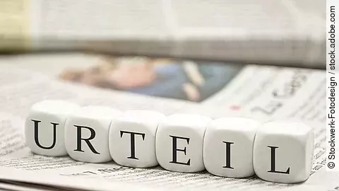 Urteil Buchstabenwürfel bilden das Wort "Urteil". Sie liegen auf einer Zeitung.