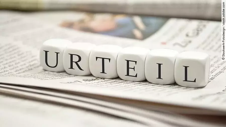 Buchstabenwürfel bilden das Wort "Urteil". Sie liegen auf einer Zeitung.