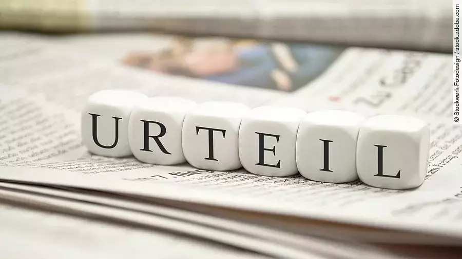 Buchstabenwürfel bilden das Wort "Urteil". Sie liegen auf einer Zeitung.