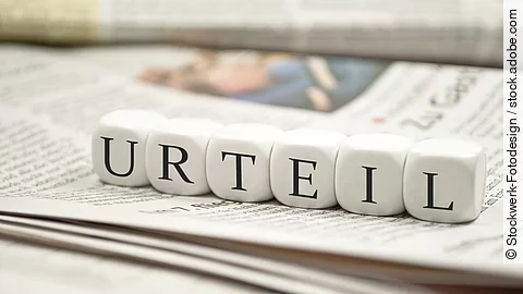 Urteil Buchstabenwürfel bilden das Wort "Urteil". Sie liegen auf einer Zeitung.