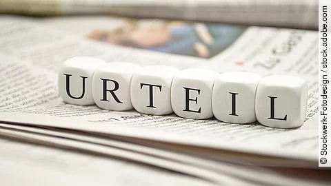 Urteil Buchstabenwürfel bilden das Wort "Urteil". Sie liegen auf einer Zeitung.