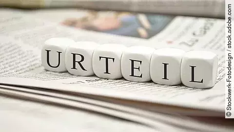 Urteil Buchstabenwürfel bilden das Wort "Urteil". Sie liegen auf einer Zeitung.