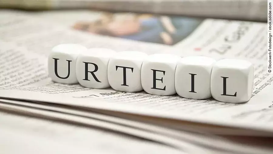 Buchstabenwürfel bilden das Wort "Urteil". Sie liegen auf einer Zeitung.