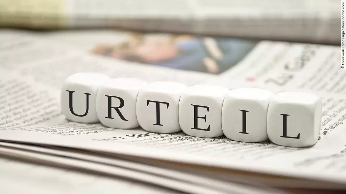 Buchstabenwürfel bilden das Wort "Urteil". Sie liegen auf einer Zeitung.