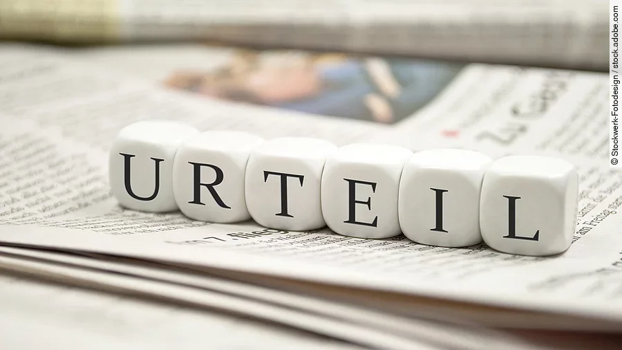 Urteil Buchstabenwürfel bilden das Wort "Urteil". Sie liegen auf einer Zeitung.