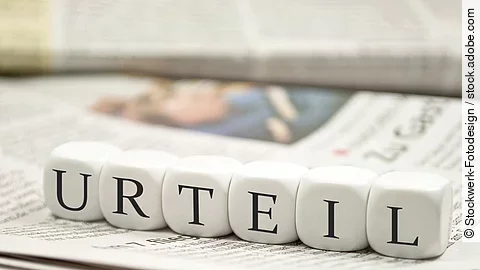 Urteil Buchstabenwürfel bilden das Wort "Urteil". Sie liegen auf einer Zeitung.