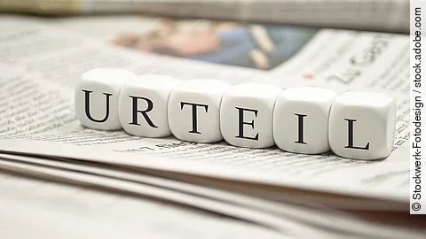 Urteil Buchstabenwürfel bilden das Wort "Urteil". Sie liegen auf einer Zeitung.