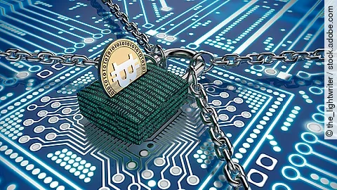 Ein Schloss mit binärem Code versehen liegt auf einem Chip. Das Schloss wird gehalten von vier Ketten und stellt so den Datenschutz dar.