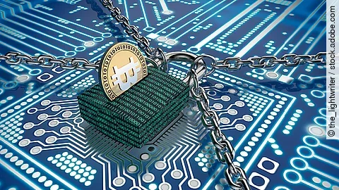 Ein Schloss mit binärem Code versehen liegt auf einem Chip. Das Schloss wird gehalten von vier Ketten und stellt so den Datenschutz dar.