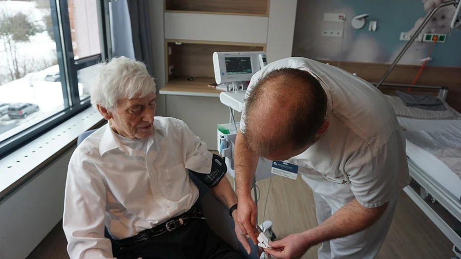 Michael Hirschmann legt Fingersensor an den Patienten an Michael Hirschmann legt Fingersensor an den Patienten an