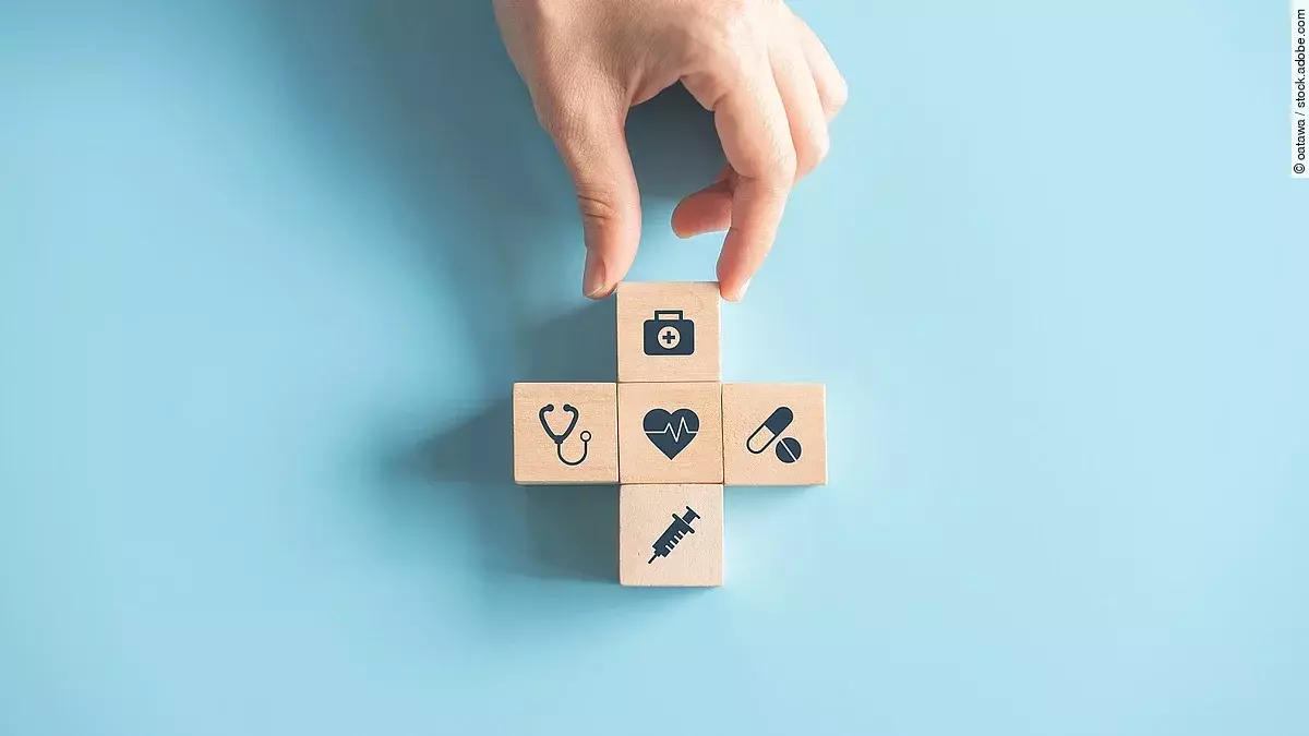 Kreuz aus Holzwürfeln mit Symbolen der Gesundheitsversorgung