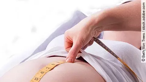 Hebamme Zu sehen sind die Hände einer Hebamme, die den Bauch einer schwangeren Frau abmisst.