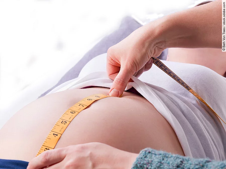 Hebamme Zu sehen sind die Hände einer Hebamme, die den Bauch einer schwangeren Frau abmisst.