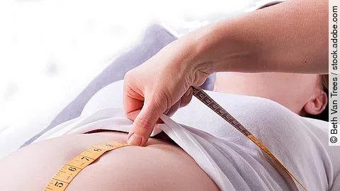 Hebamme Zu sehen sind die Hände einer Hebamme, die den Bauch einer schwangeren Frau abmisst.