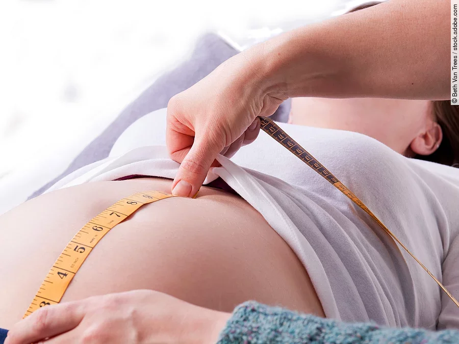 Hebamme Zu sehen sind die Hände einer Hebamme, die den Bauch einer schwangeren Frau abmisst.