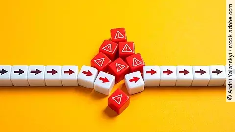 Rote Pfeile in weißen Würfeln vor gelbem Hintergrund, die aufgrund einer augestauten Last zusammenbrechen.