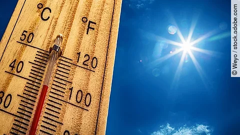 Ein Thermometer, das 40 Grad Celsius zeigt neben blauem Himmel und Sonne