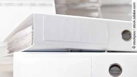 Aktenordner Zwei weiße Aktenordner liegen übereinander. Davor liegt ein silberner Kugelschreiber.