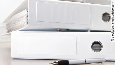 Aktenordner Zwei weiße Aktenordner liegen übereinander. Davor liegt ein silberner Kugelschreiber.