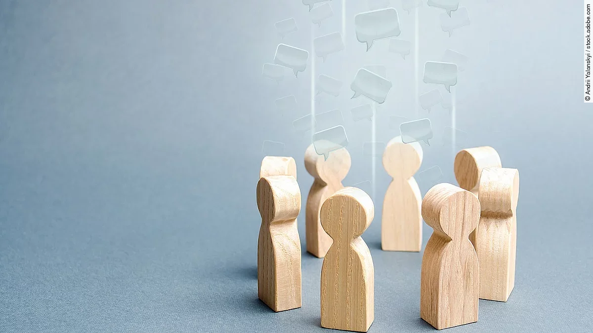 Gespräch Kleine Holzfiguren sind in einem Kreis angeordnet