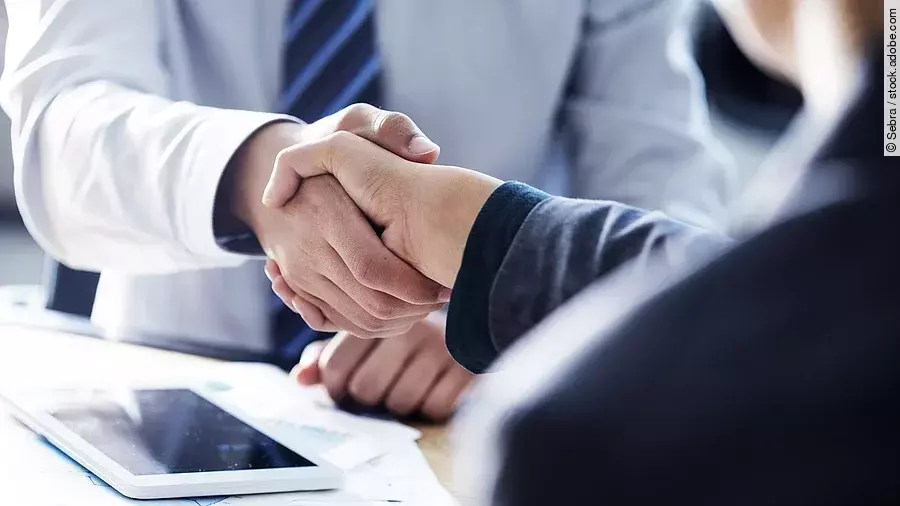 Händeschütteln Händeschütteln zweier sich gegenübersitzenden Personen