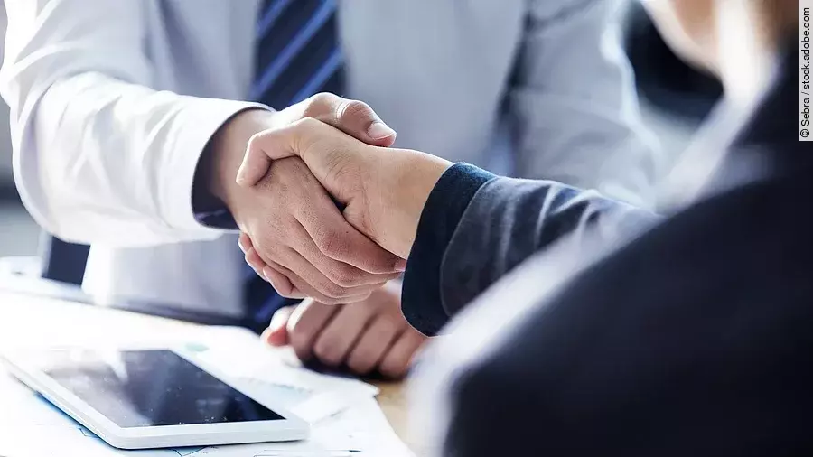 Händeschütteln Händeschütteln zweier sich gegenübersitzenden Personen