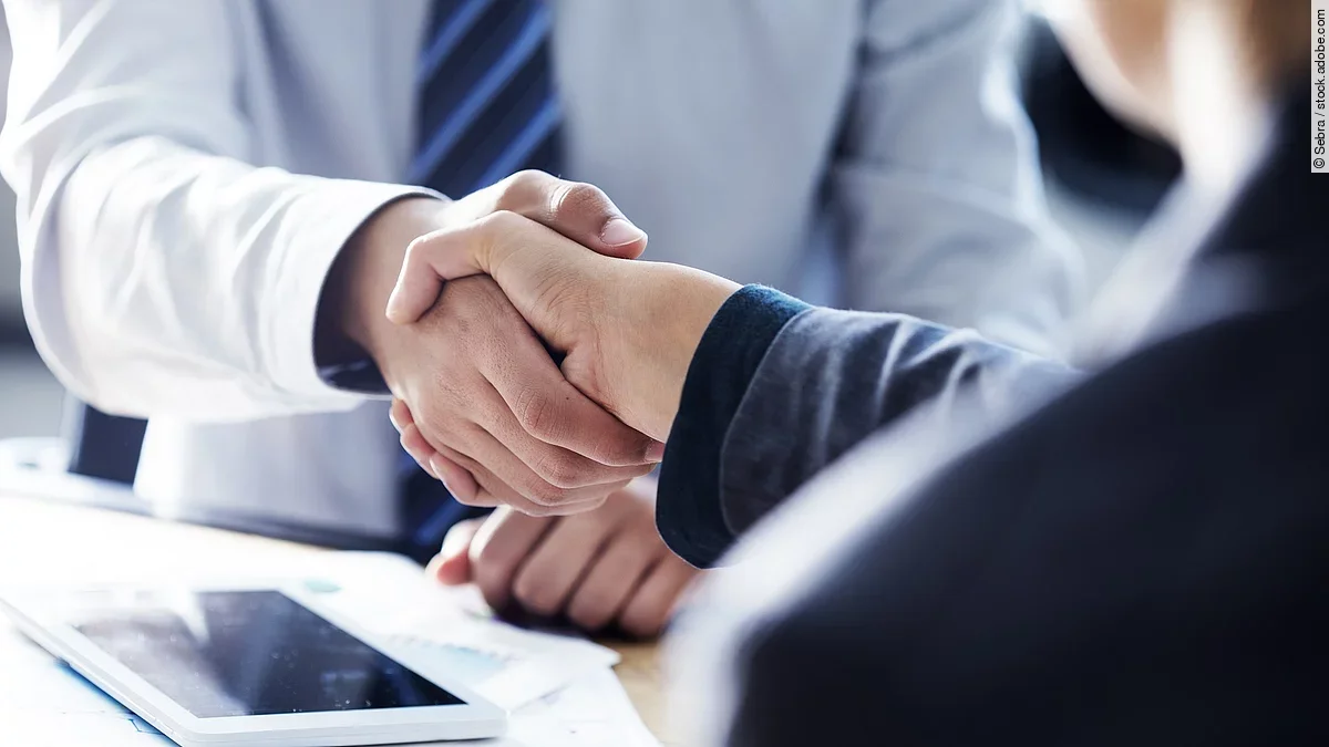 Händeschütteln Händeschütteln zweier sich gegenübersitzenden Personen